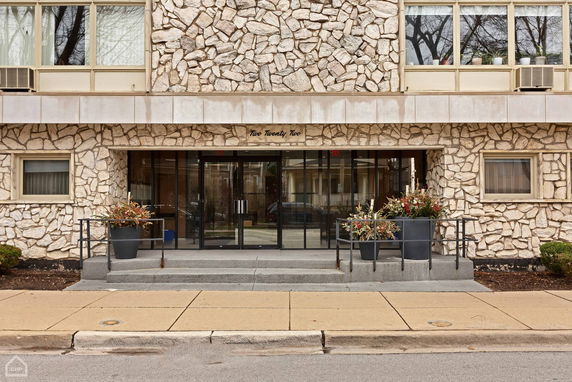 Front view of a building with a stone facade and glass entrance.