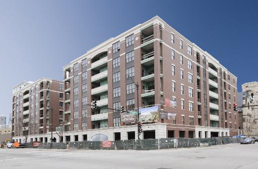 Front view of a large multi-story apartment building with balconies.