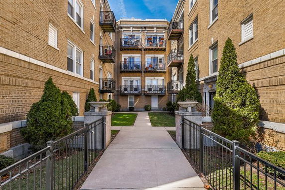 Front view of a multi-story apartment building with balconies.