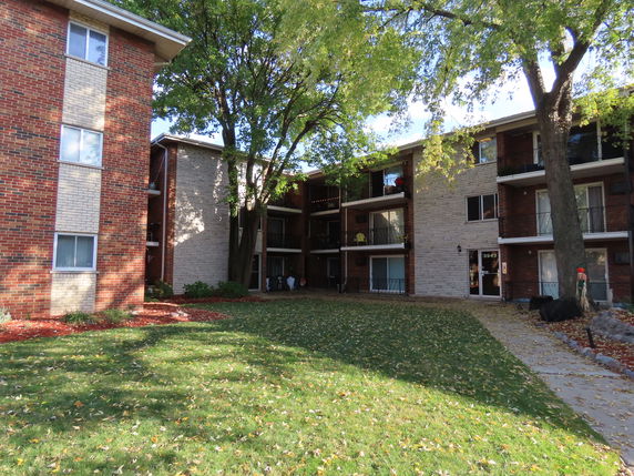 Front view of a multi-story residential building with brick and stone facade.