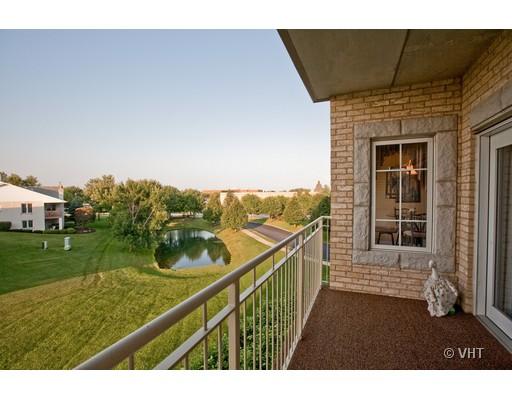 View from a building balcony overlooking a lawn and small pond.
