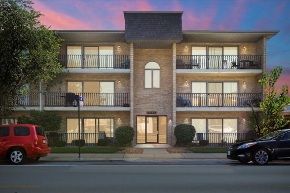 Front view of a three-story apartment building with balconies.