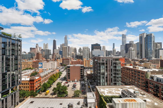 Cityscape view with tall buildings under a blue sky.