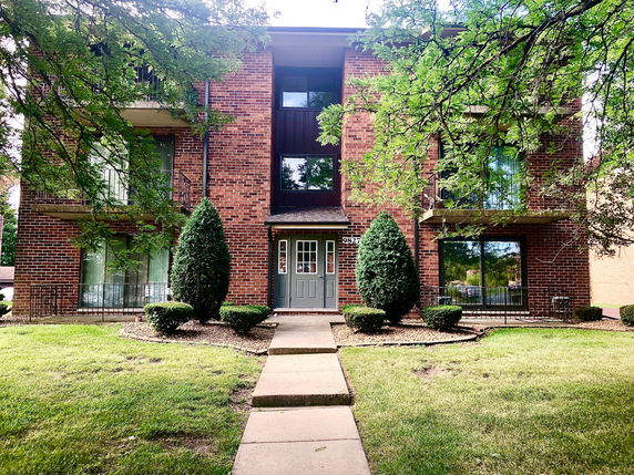 Front view of a multi-story brick building with balconies.