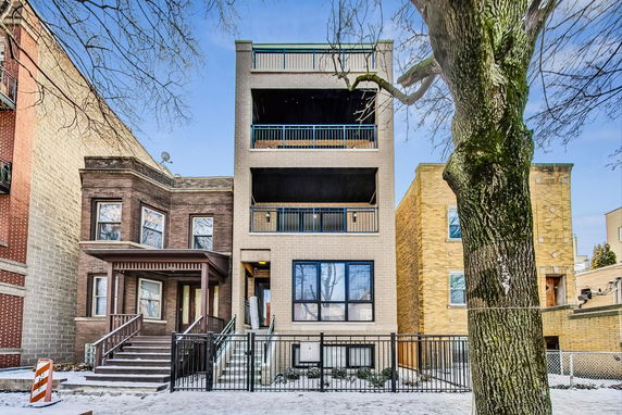 Front view of a multi-story residential building with balconies.
