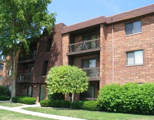 Front view of a brick apartment building with balconies.