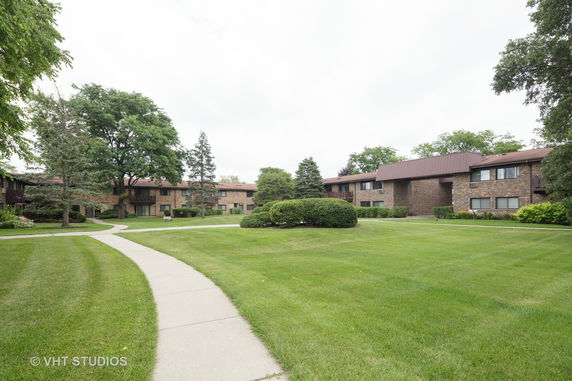 Front view of a two-story building with a landscaped lawn and pathway.