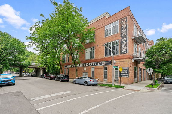 Front view of a multi-story brick building with large windows.