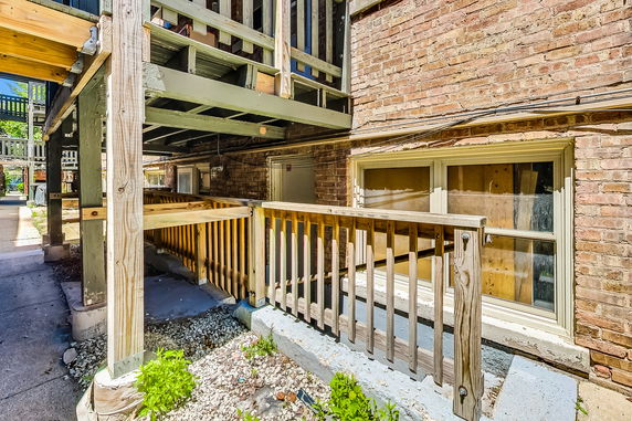 Exterior view of a building with brick walls and wooden support structures.
