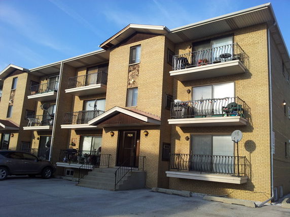 Front view of a three-story apartment building with balconies.