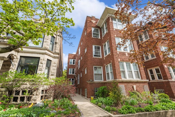 Front view of a brick apartment building with multiple floors.