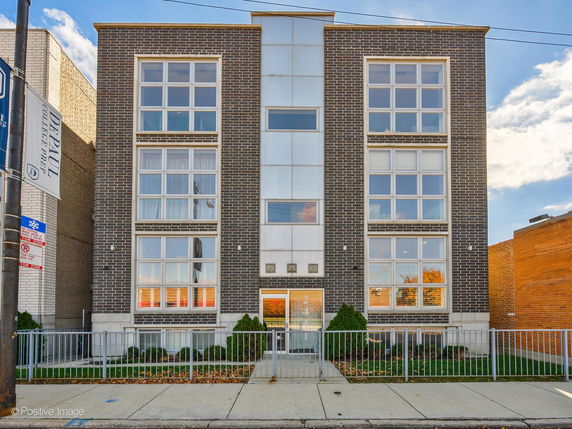 Front view of a mid-rise building with large windows and a central entrance.