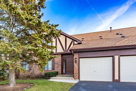 Front view of a two-story house with a garage and brick exterior.