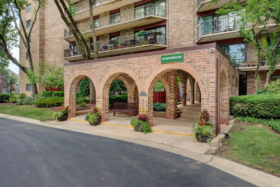 Front view of a multi-story building with brick arches and balconies.