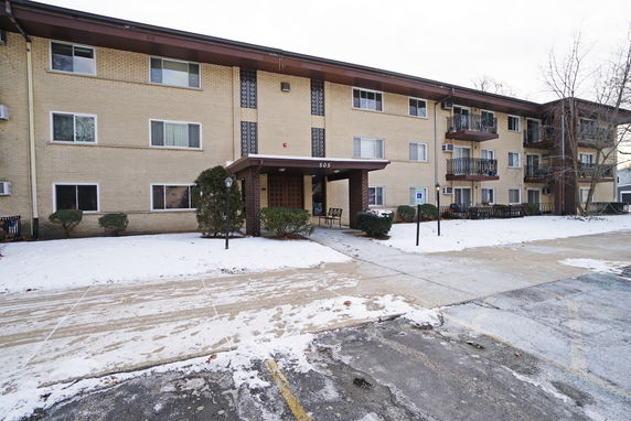 Front view of a three-story apartment building with balconies.