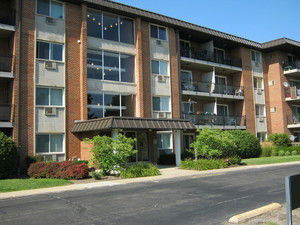 Front view of a multi-story apartment building with balconies.
