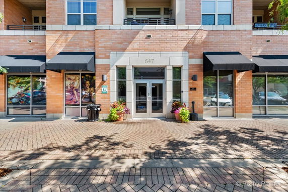 Front view of a multi-story building with large windows and an entrance with glass doors.