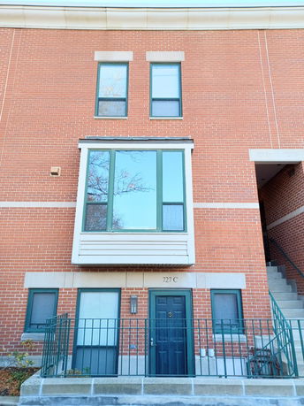 Front view of a multi-story brick building with large windows and a main entrance.