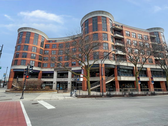 Front view of a multi-story commercial and residential building with curved design.