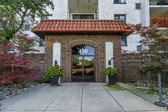 Front view of a building with a brick exterior and a tiled roof entrance.