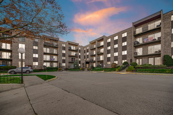 Front view of a multi-story apartment building with balconies.