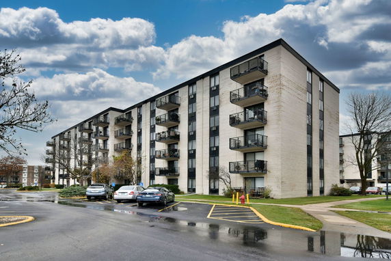 Front view of a multi-story apartment building with balconies.