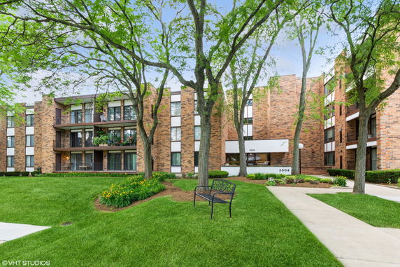 Front view of a multi-story brick apartment building with balconies.