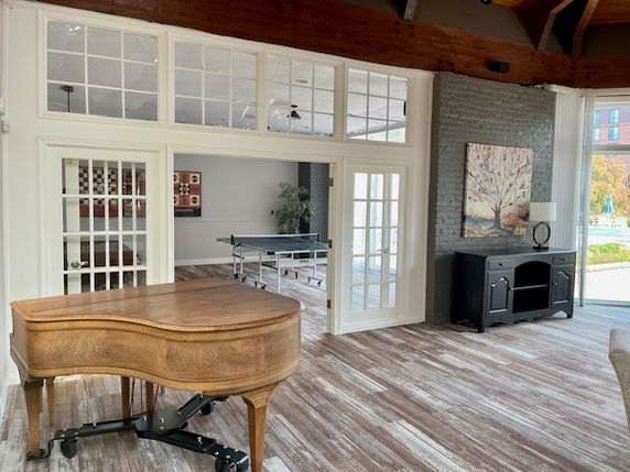 Indoor recreational area with a piano and a ping pong table.
