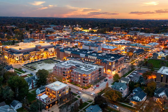Panoramic aerial view of a town with multiple buildings at dusk.