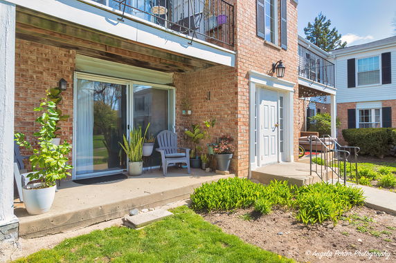 Front view of a brick house with a patio and balcony.