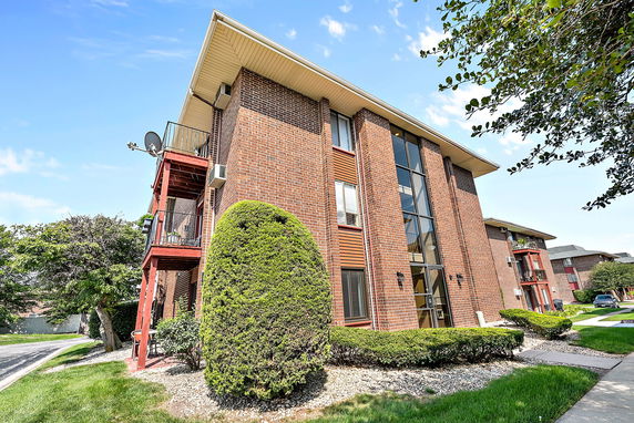 Front view of a multi-story brick building with balconies.