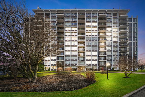 Front view of a multi-story residential building with numerous balconies.