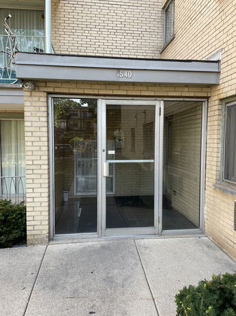 Front view of a building entrance with glass doors and a brick facade.