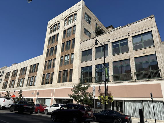 Front view of a multi-story commercial building with large windows and decorative facade.