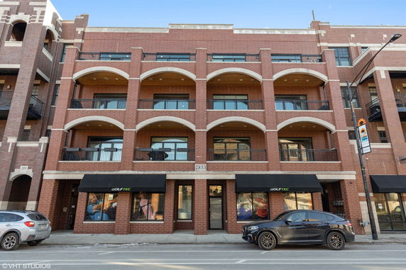Front view of a multi-story building with brick facade and large windows.