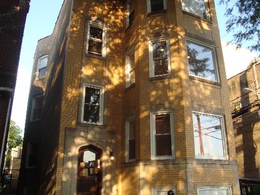 Front view of a multi-story brick building with multiple windows.