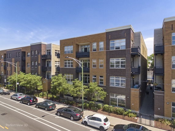 Front view of a multi-story apartment building with brick facade.