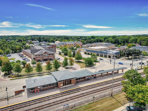 Panoramic view of a suburban area with railway tracks and surrounding buildings.