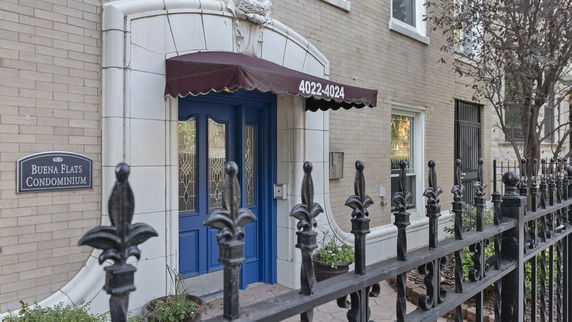 Entrance view of a condominium with a blue door and a canopy.