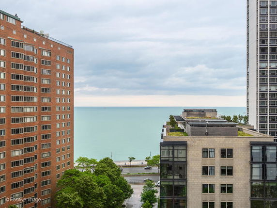 Wide angle view from a high-rise building overlooking the ocean and surrounding buildings.