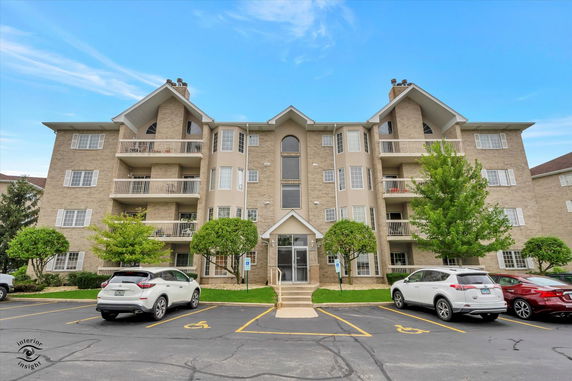 Front view of a multi-story apartment building with balconies.