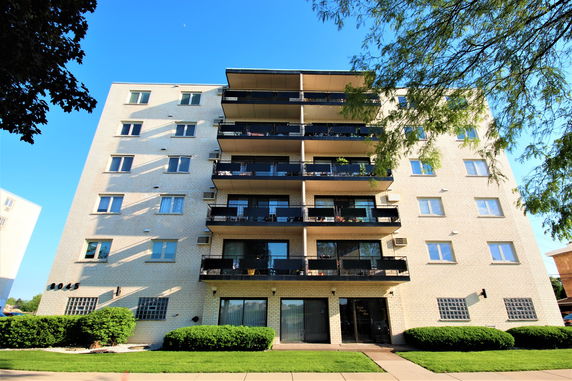 Front view of a multi-story apartment building with balconies.