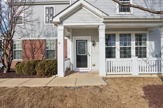 Front view of a house with a porch and brick accents.