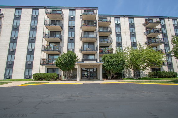 Front view of a multi-story apartment building with balconies.