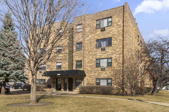 Front view of a multi-story brick apartment building.