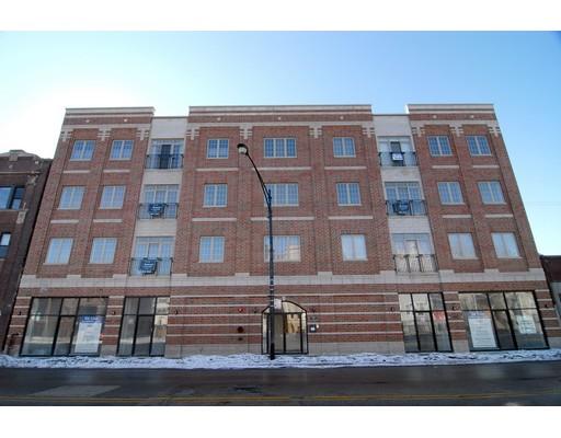Front view of a multi-story brick building with windows and glass doors.