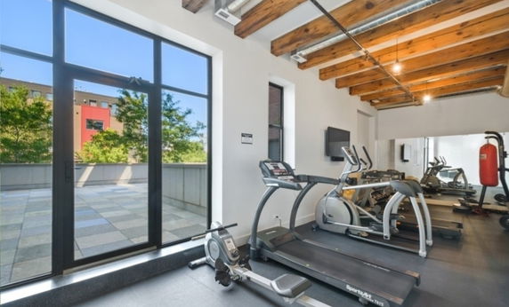 Gym area with large windows and exercise equipment.