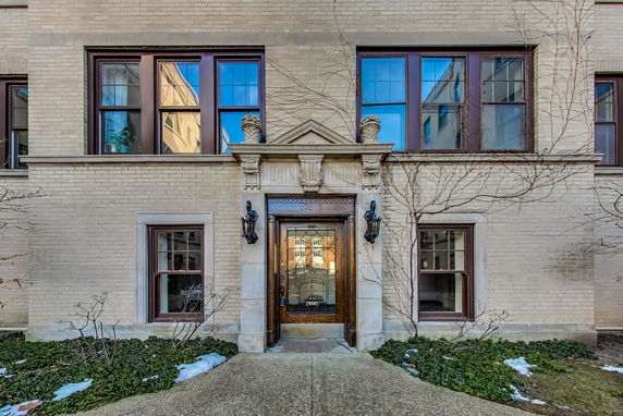 Front view of a building entrance with decorative stonework and windows.