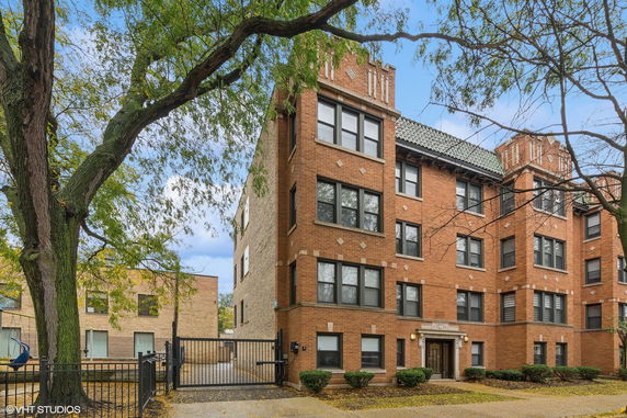 Front view of a multi-story brick building with large windows.