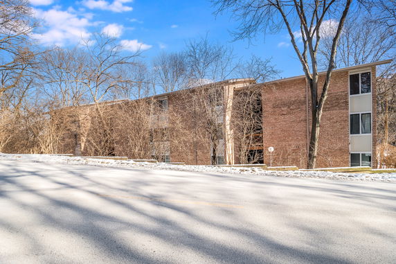 Front view of a multi-story brick building with several windows.